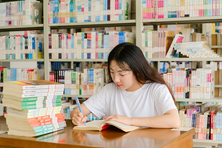 人像白天女大学生图书馆写字摄影图配图