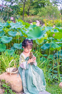 端午节小可爱摄影照片_荷塘姑娘下午儿童荷花池坐吃摄影图配图