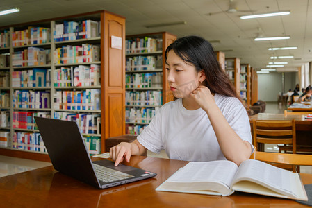 毕业摄影照片_人像白天美女图书馆玩电脑摄影图配图