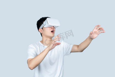 vr虚拟现实摄影照片_年轻白t男性戴VR眼镜体验虚拟现实游戏