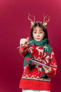 麋鹿角摄影照片_圣诞节创意圣诞装扮麋鹿角女性拿着笔指前方