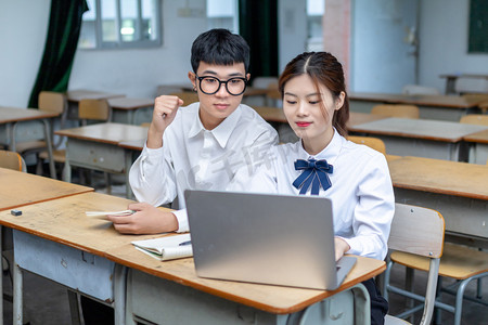 在校园里用电脑学习的青春大学生