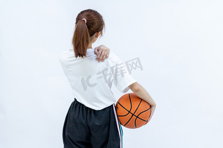 手拿篮球的女学生揉背面肩膀