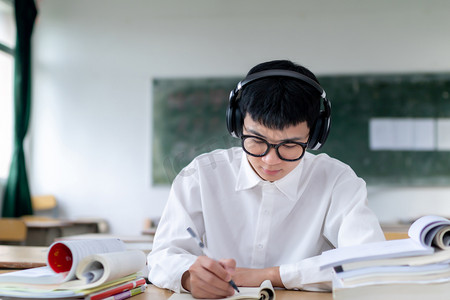课室里听音乐复习做题的男学生