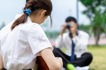 男生给拿着尤克里里的女生拍照背景