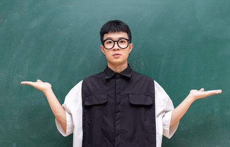 正在课室黑板做展示动作的男生