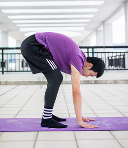 在瑜伽垫上运动健身练习独脚站的年轻男性