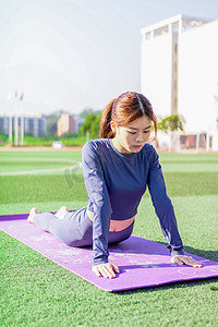 运动冥想摄影照片_穿瑜伽服在瑜伽垫上运动健身练习的运动女性特写