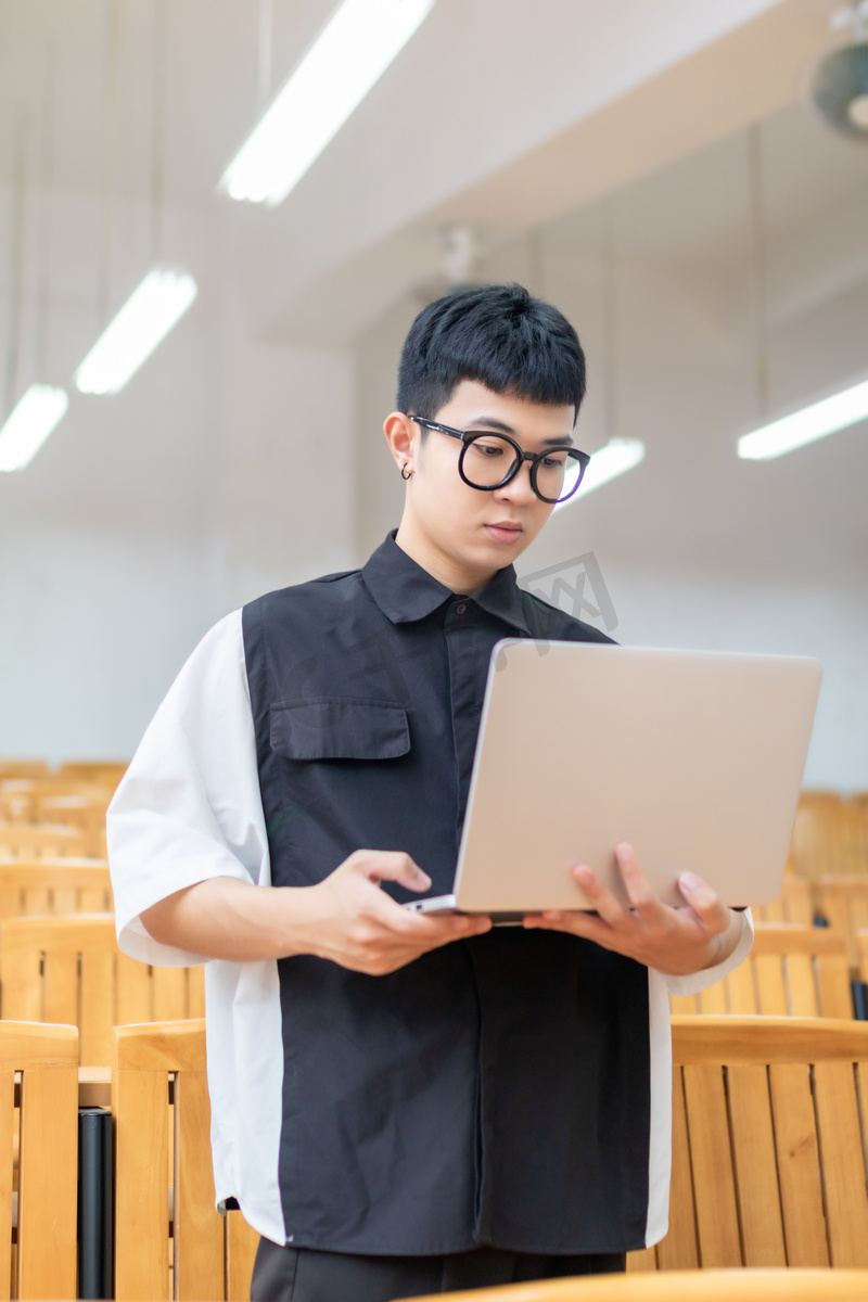 教室里使用笔记本电脑学习的男大学生高清摄影大图 千库网