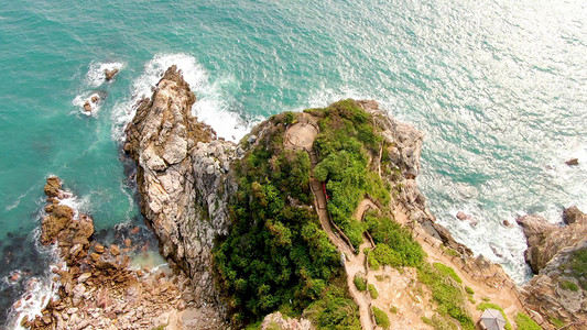 中国十大未解之谜摄影照片_航拍蔚蓝色大海边礁石岛屿自然风光