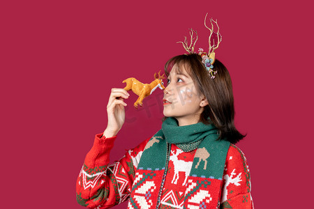 麋鹿角摄影照片_圣诞节创意圣诞装扮麋鹿角女性与麋鹿玩偶