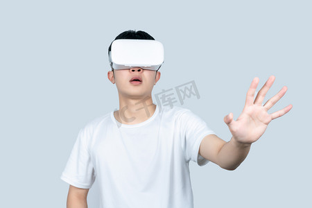 vr虚拟现实摄影照片_年轻白t男性戴VR眼镜体验虚拟现实