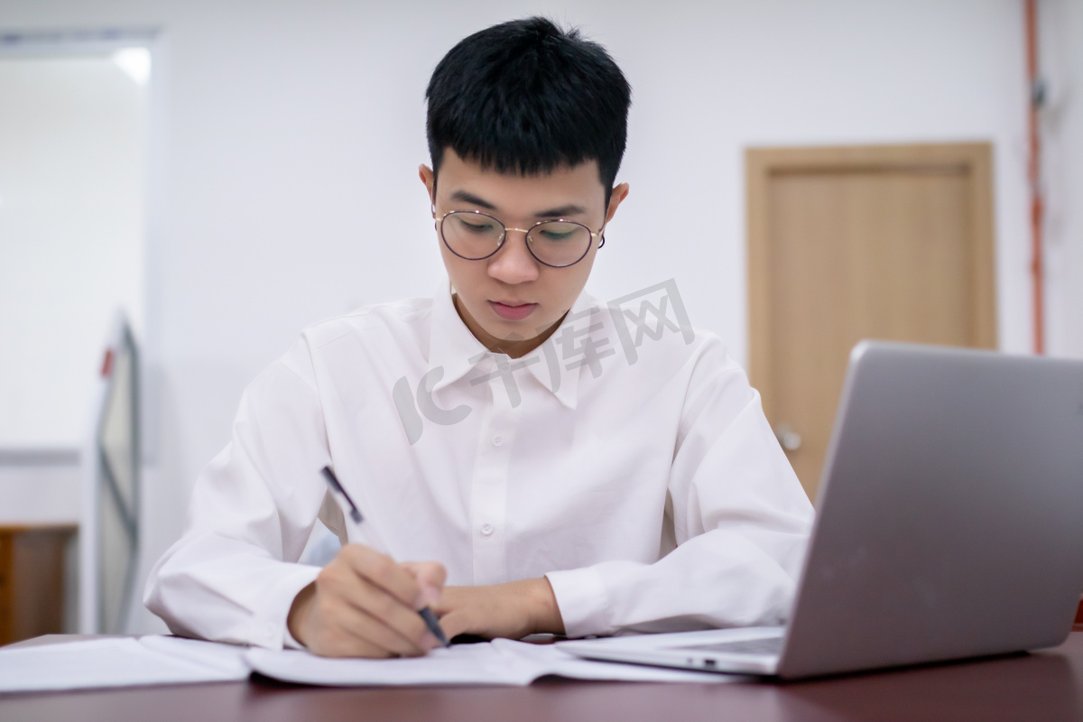 图书馆看书的男大学生认真做题高清摄影大图 千库网
