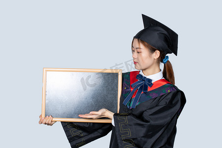 毕业季青春女大学生手拿着小黑板展示