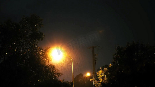 街道夜摄影照片_瓢泼大雨路灯微光实景