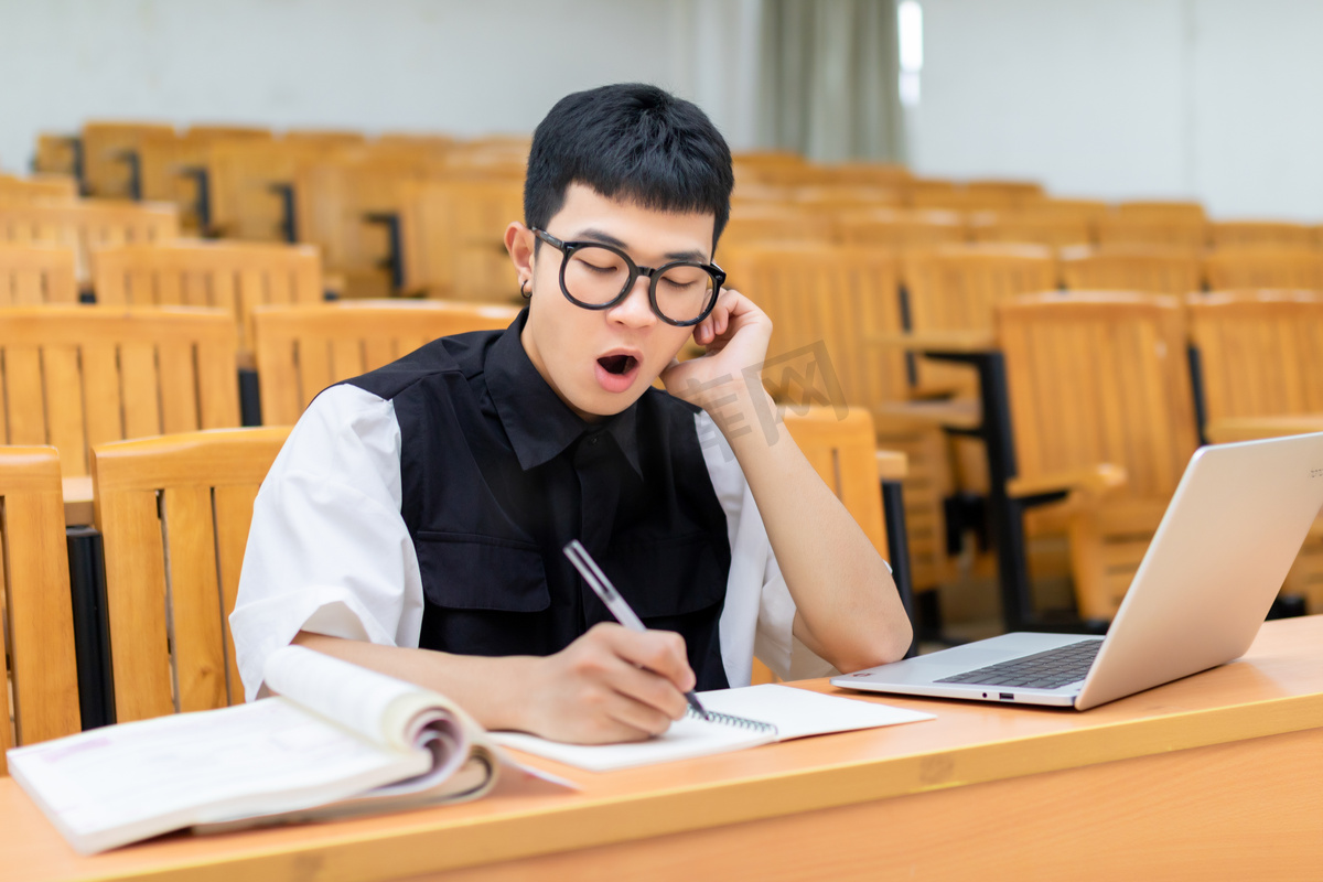 教室里使用笔记本电脑学习的男大学生打瞌睡高清摄影大图 千库网