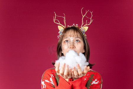 创意平安夜摄影照片_圣诞节创意圣诞装扮麋鹿角女性手拿棉花