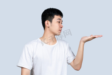 白色短袖青年男子看手中的东西动作展示