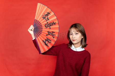 新年甜美女性手拿恭喜发财扇子扇风