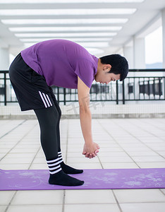 在瑜伽垫上运动健身拉筋的年轻男性