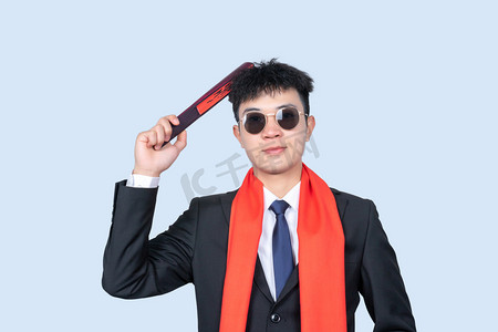 春节扇子扇子摄影照片_新年商务男性手拿扇子戴墨镜敲头