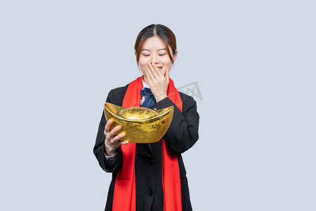 商务春节摄影照片_新年商务女性手拿金元宝开心表情