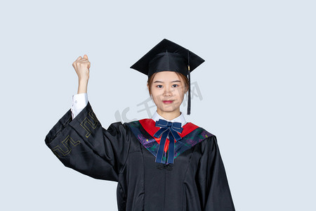 做加油打气动作手势的毕业女大学生