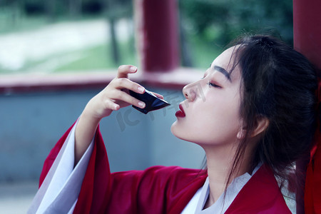 古风喝酒摄影照片_中国风白天汉服写真室外喝酒动作摄影图配图