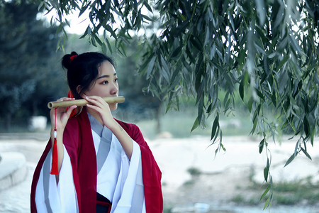 国潮白天汉服女侠树下吹笛子摄影图配图