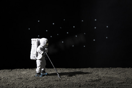 宇宙星球图摄影照片_探索宇宙夜晚宇航员模拟月球创意微距摄影图配图