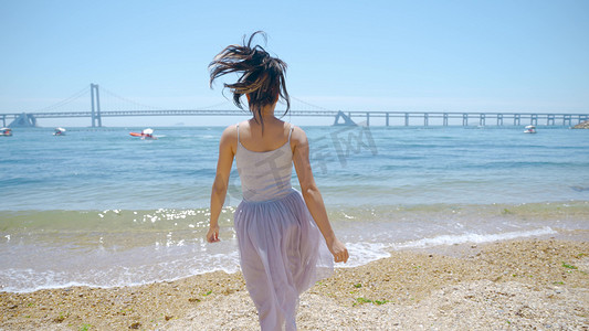 朝气摄影照片_夏天美女在海边笑脸奔跑背影