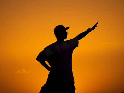人像剪影黄昏一个男人夕阳下胜利开心的剪影摄影图配图