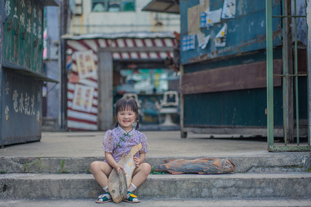 九龙城寨摄影照片_卖咸鱼的女孩下午儿童香港街笑摄影图配图