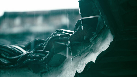 实拍雨水滴落在瓦片屋檐上