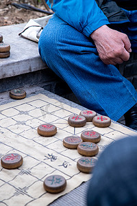 棋盘对弈摄影照片_城市白天象棋老人下棋摄影图配图