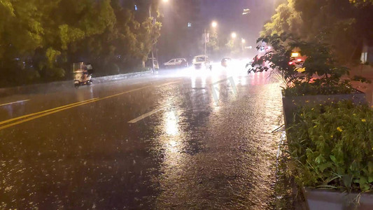 大雨中马路上行驶的车辆摄影图