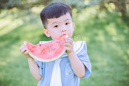 西瓜摄影照片_人物形象夏天男童户外吃西瓜摄影图配图