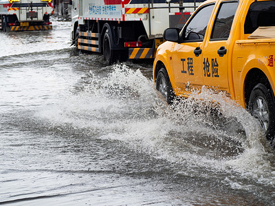 风挡大雨摄影照片_城市救援车白天工程抢险车积水中前行摄影图配图
