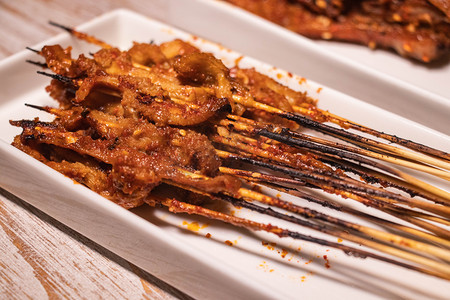 香辣芝麻干锅牛蛙摄影照片_美食夜晚香辣鱿鱼串美食大排档用餐摄影图配图