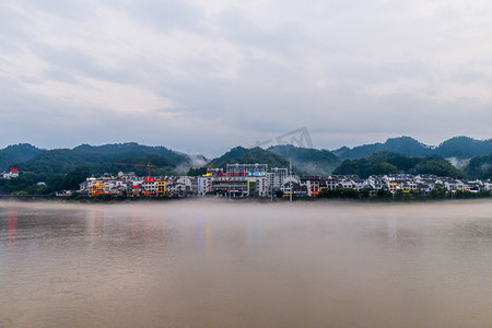 河流洪水涨水图片傍晚河流洪水建筑户外高视角摄影图配图