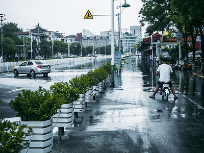 大雨水摄影照片_城市大雨白天城市街道积满水的景象摄影图配图