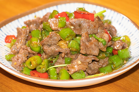 盘摄影照片_美食中午一盘尖椒炒肉菜品餐馆用餐摄影图配图