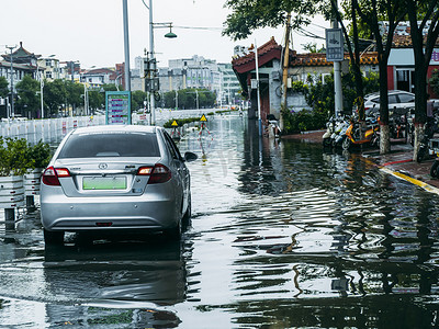 暴雨摄影照片_被淹的城市白天汽车在积水中停着摄影图配图