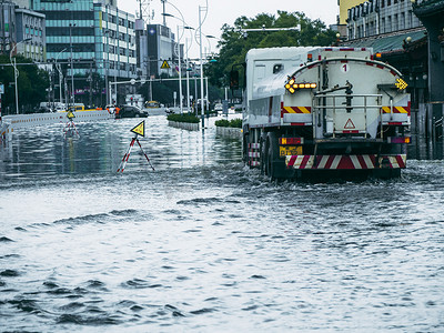 城市大雨摄影照片_被淹的城市阴天救援车积水里前行摄影图配图