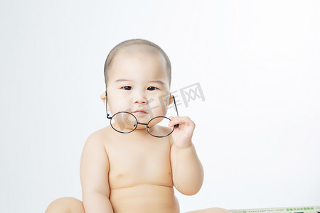 宝宝启蒙摄影照片_婴儿教育白天可爱男婴室内摘下眼镜摄影图配图