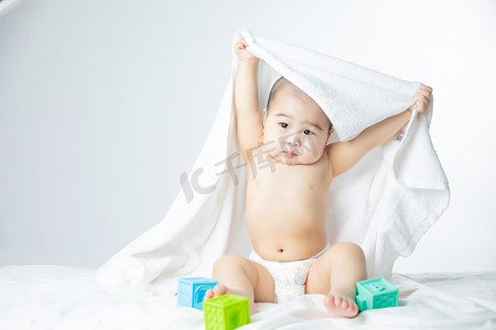 人物卡通线条黑白摄影照片_婴儿白天玩玩具的男婴儿室内床上抬手摄影图配图人物