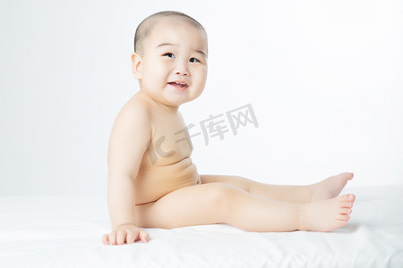 宝宝启蒙摄影照片_婴儿白天坐在床上的婴儿室内坐着摄影图配图