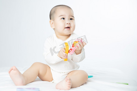 宝宝穿棉衣服摄影照片_婴儿白天玩耍的婴儿室内玩玩具摄影图配图