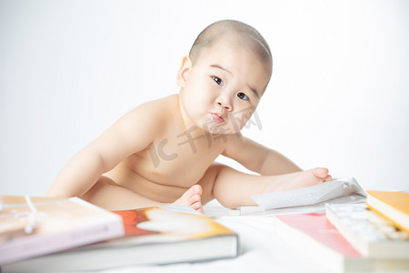 宝宝启蒙摄影照片_婴儿启蒙教育白天书堆里的婴儿室内嘟嘴巴摄影图配图