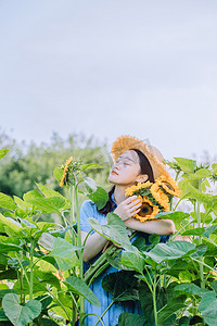 文艺夏天白天向日葵花田里的美女户外拿着向日葵摄影图配图